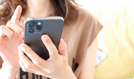 ペットシッターの依頼を考えている女性がスマホで問い合わせする様子