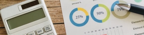 電卓と報告書が机に置いてある様子